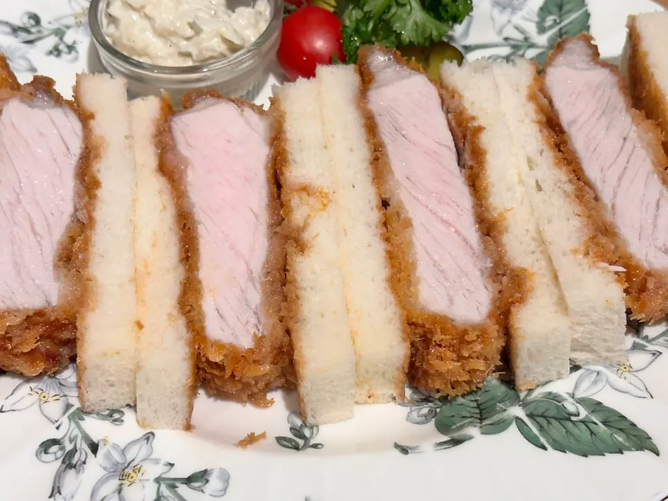 Katsu sando served with pickles and cherry tomatoes