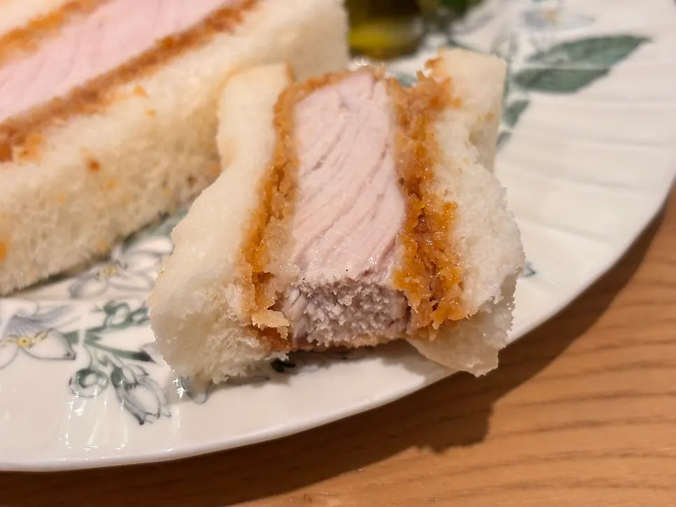 A piece of katsu sando showing tender meat