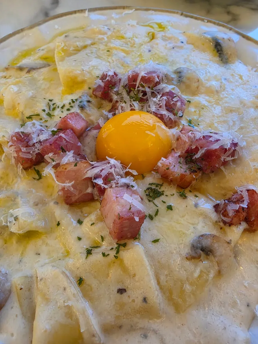 Flat carbonara served with egg yolk