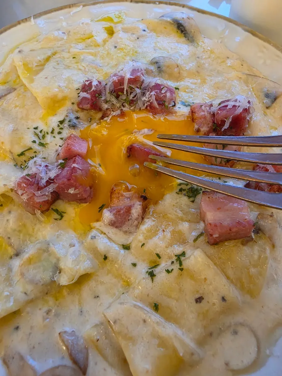 Flat carbonara served with egg yolk