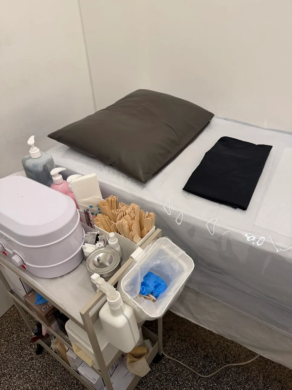 Waxing treatment bed with a pad laid on top
