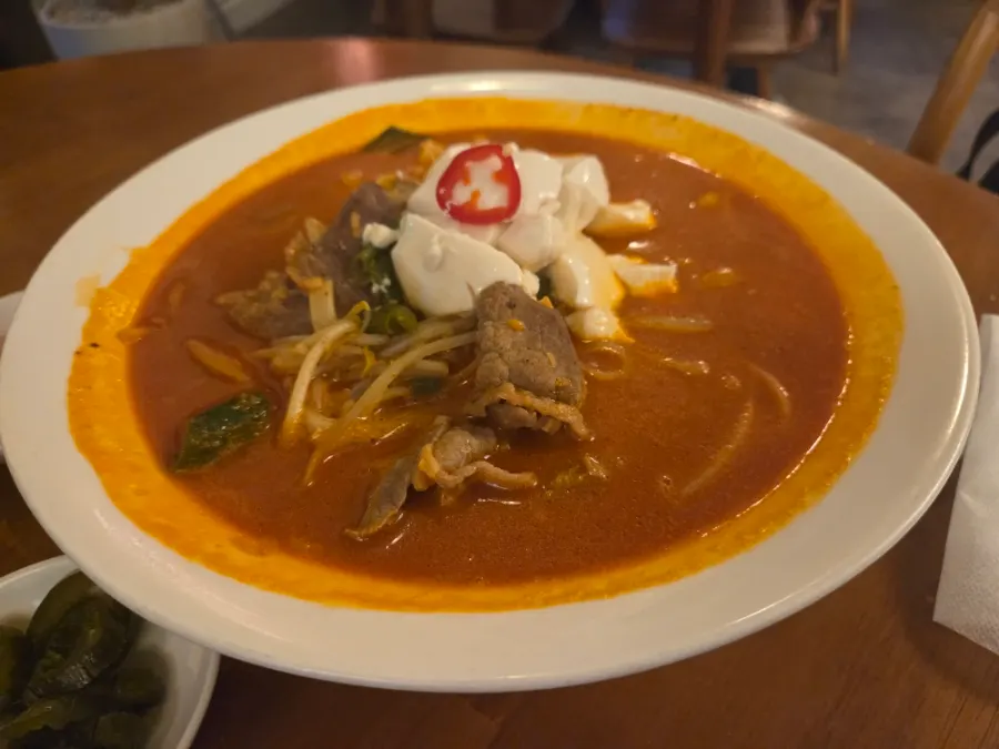 A bowl of brisket sundubu kalguksu