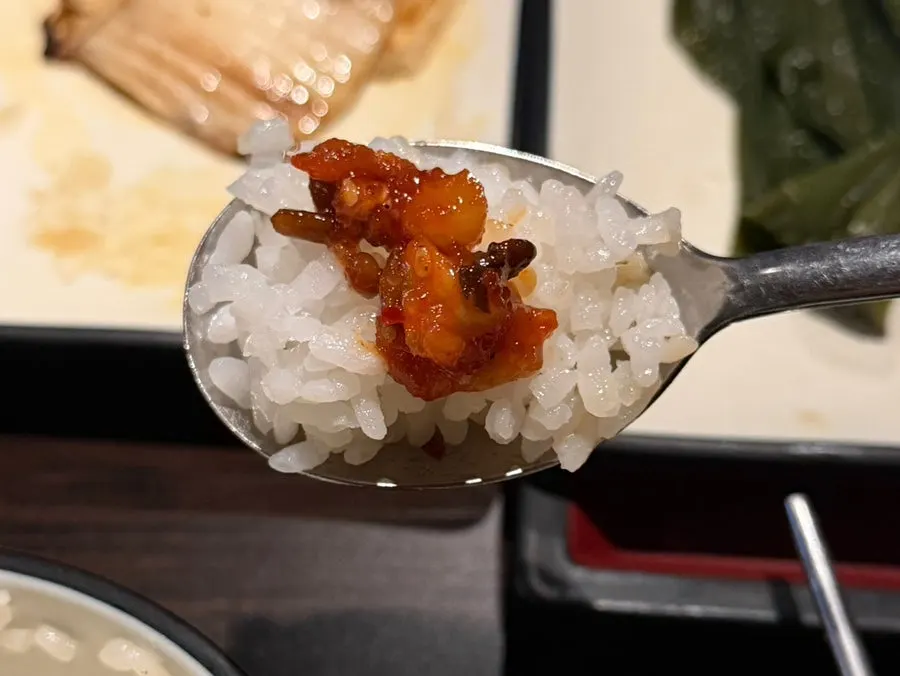A spoonful of rice topped with doenjang jjigae and jeotgal