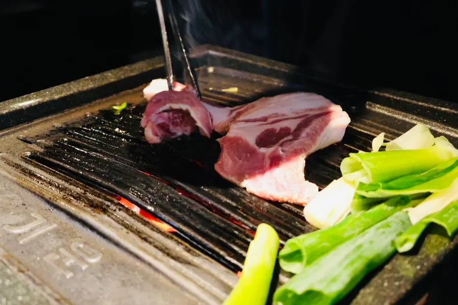 직원이 숯불에 갈비삼겹을 굽는 모습