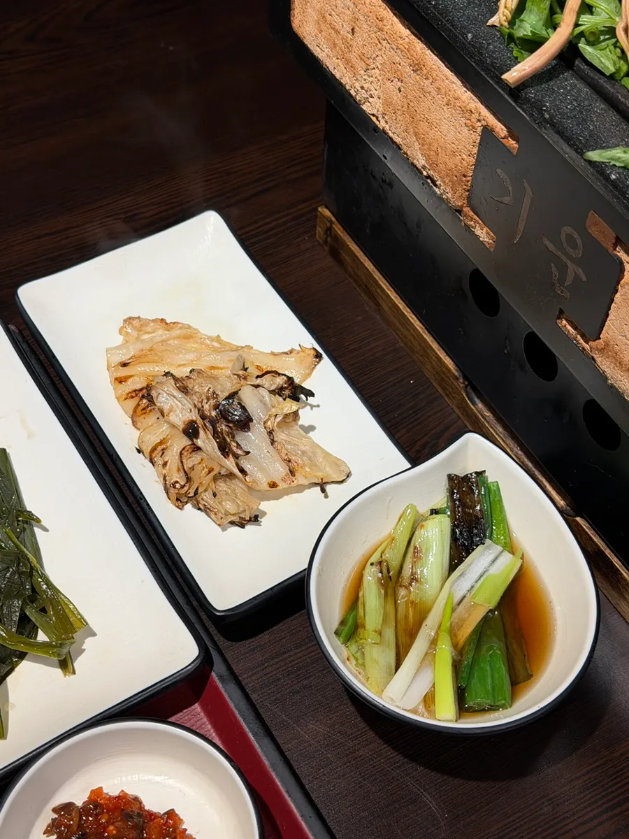 Grilled green onion and white kimchi served alongside