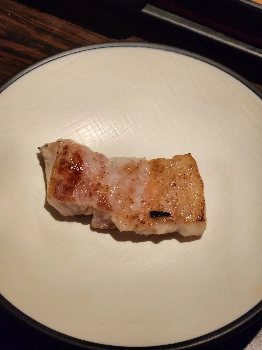 A golden-brown grilled piece of samgyeopsal