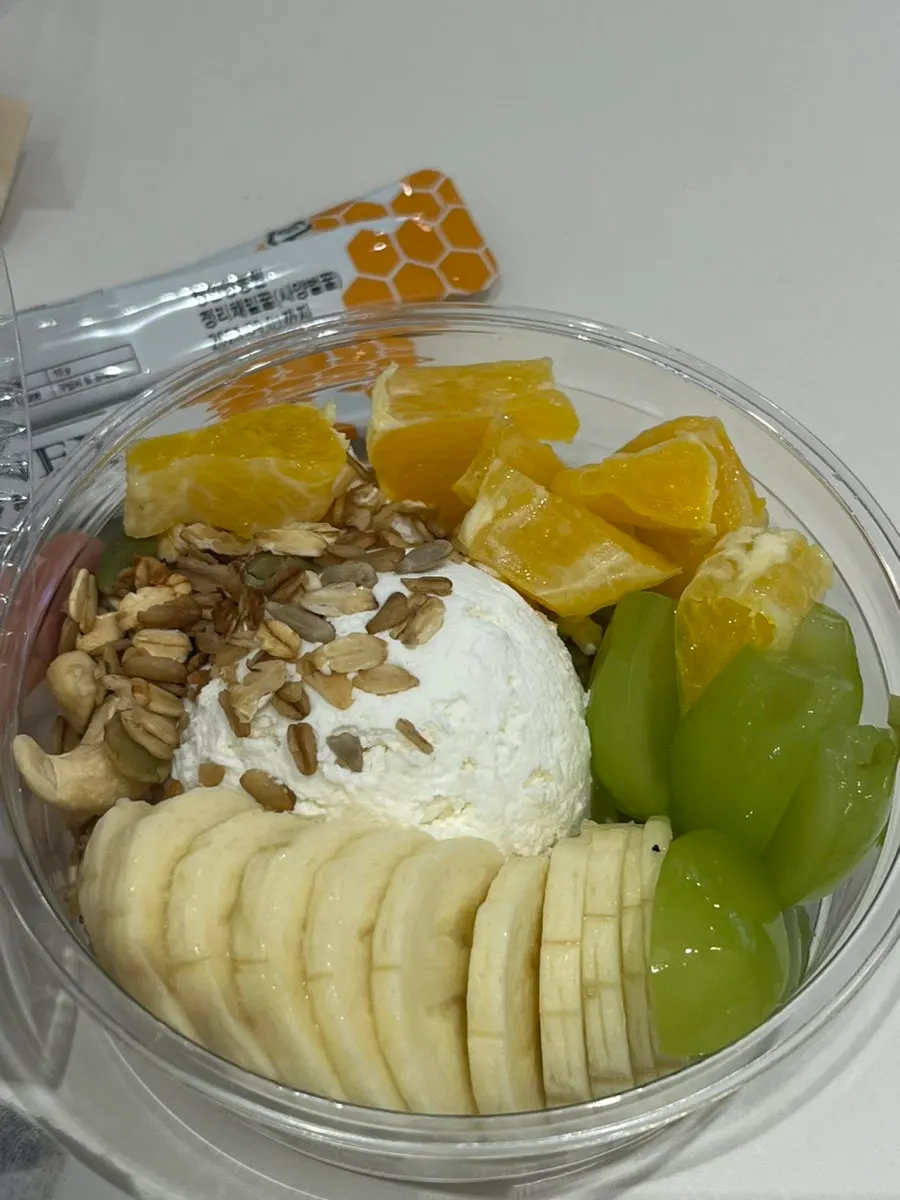 Claire Single yogurt topped with orange, green grapes, and banana