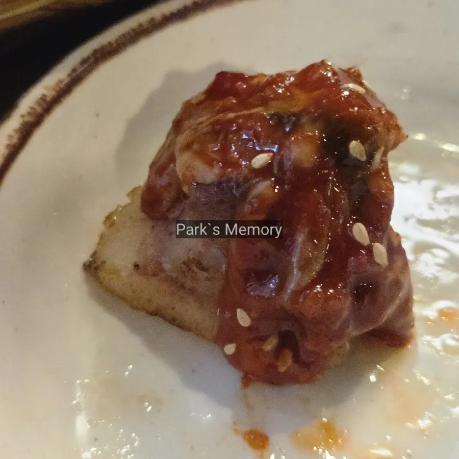 A piece of pork neck topped with seafood salad
