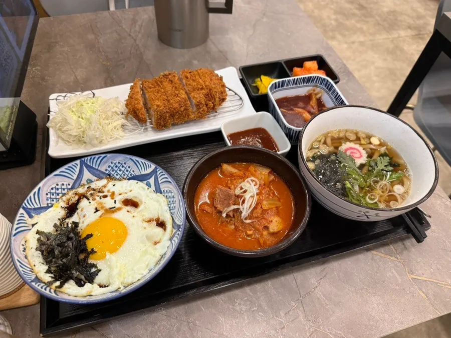 Table spread with pork kimchi jjigae and pork cutlet served together
