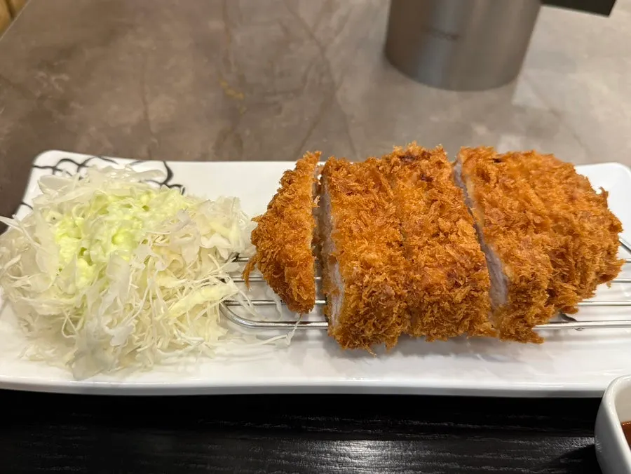 Plate of pork cutlet served with shredded cabbage