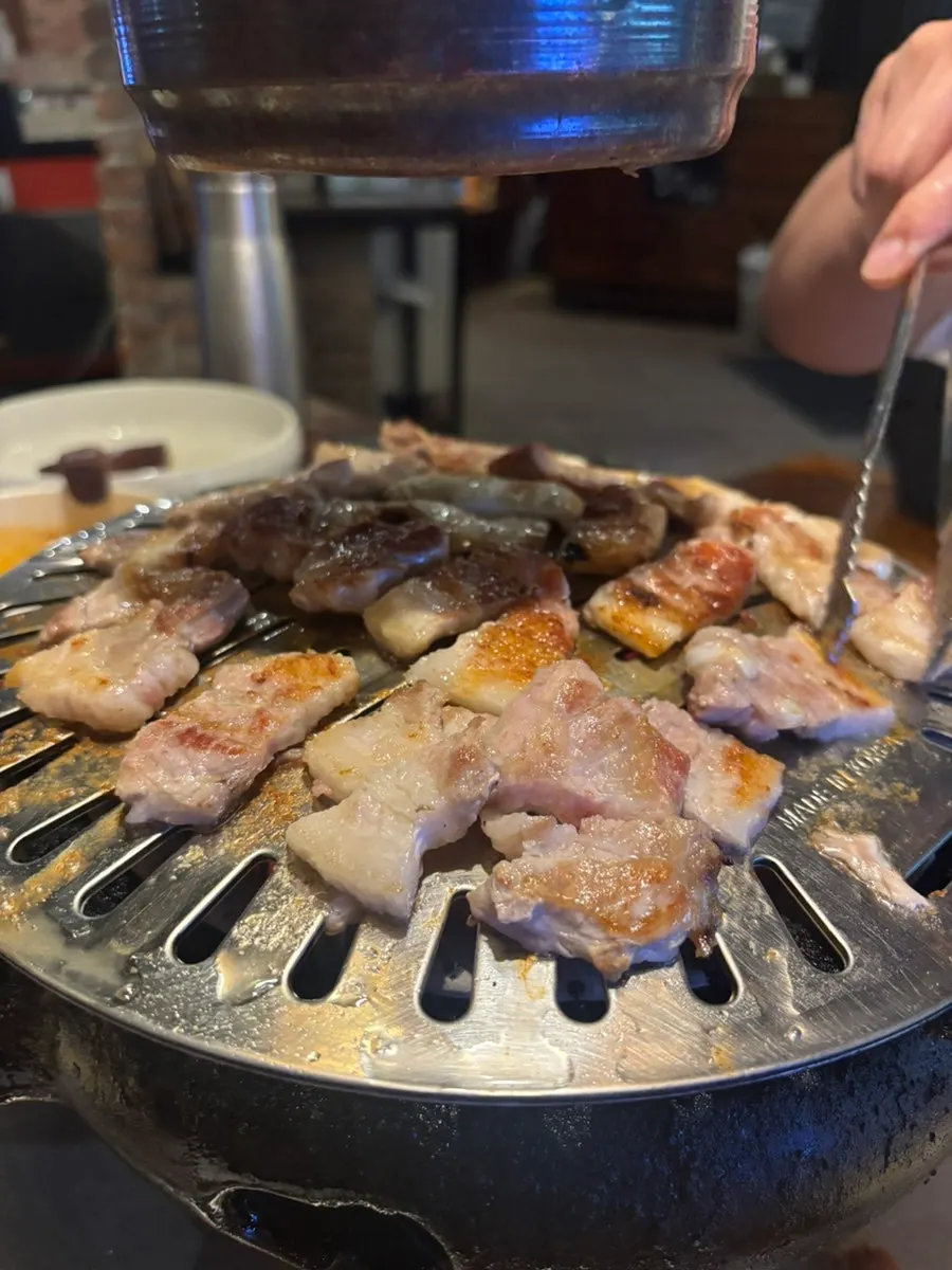Cut pork belly grilling over a brazier