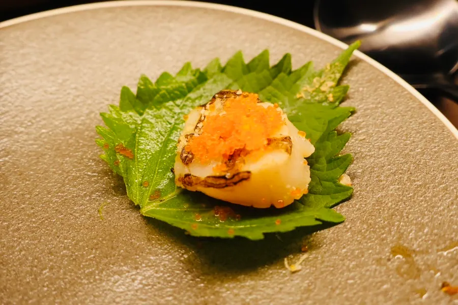 Scallop sashimi topped with flying fish roe