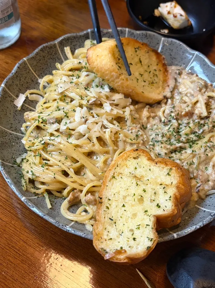 Pasta piled with ragu sauce, served with bread