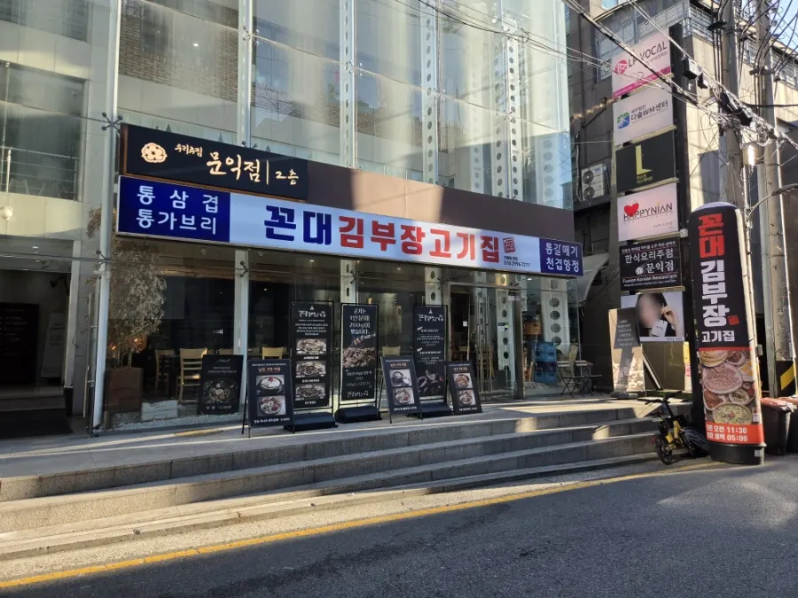 Exterior of Kkondae Kim Bujang Gogi-jip Gangnam Station Branch with glass front and large sign