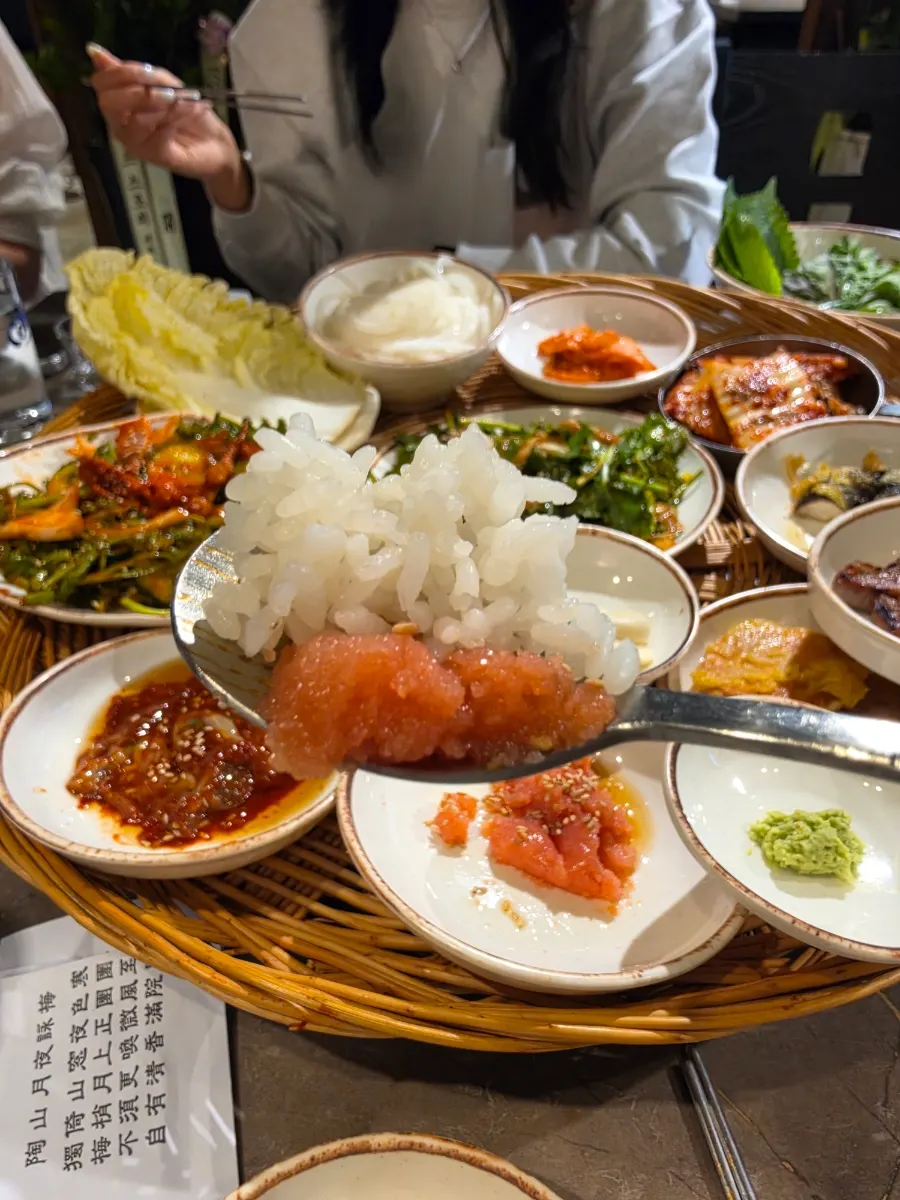 A full spread of lettuce and banchan served in a basket