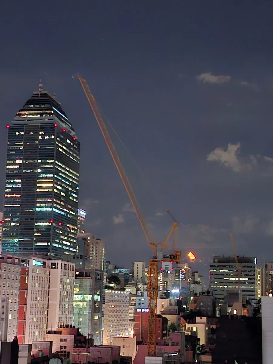 A huge, low-hanging moon seen from the rooftop