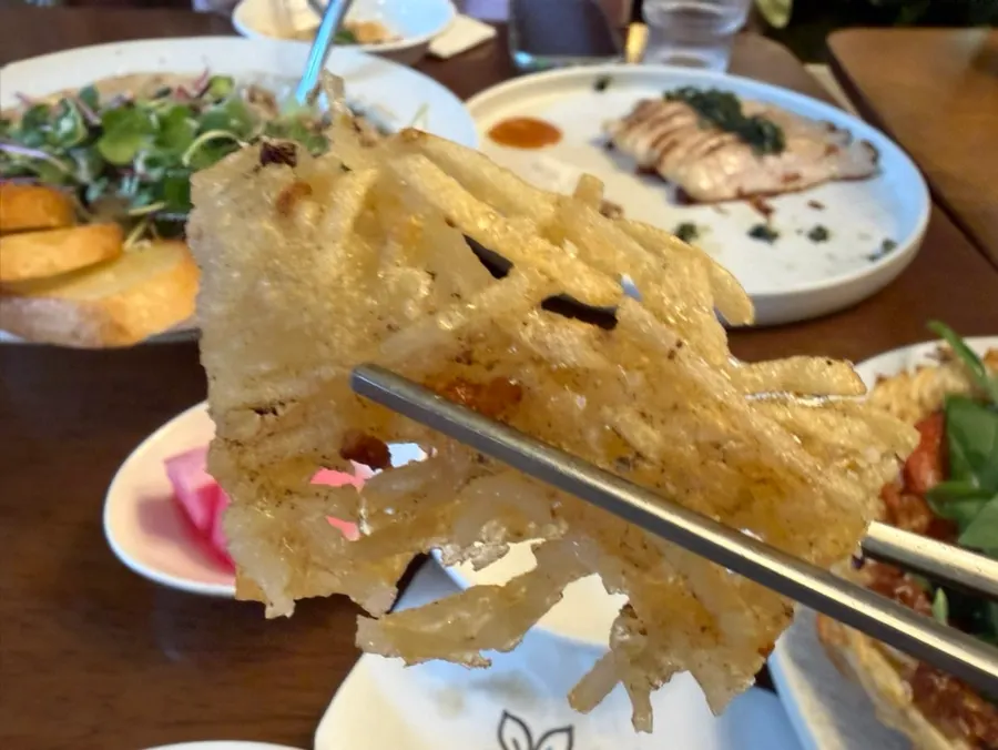 A piece of arugula cheese potato pancake with stretching cheese