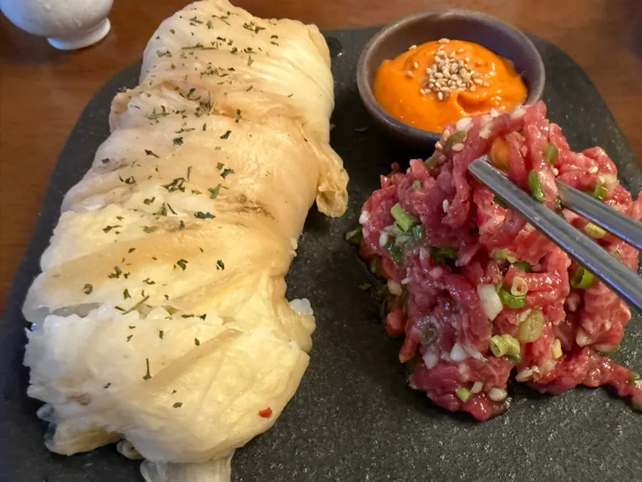 A plate of Korean beef tartare with aged kimchi wraps