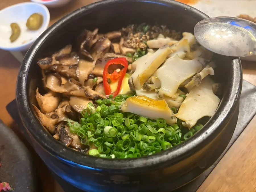 A bite of aged kimchi and rice topped with beef tartare