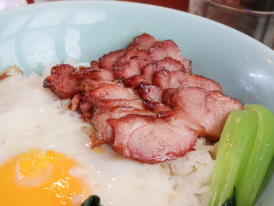 A bowl of char siu rice bowl drizzled with sauce