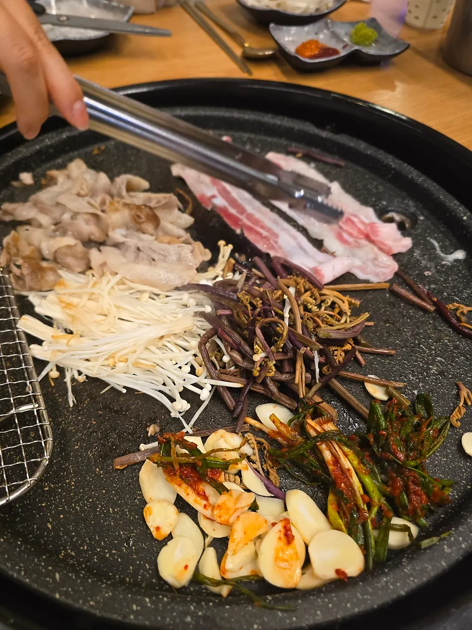 A piece of daepae samgyeopsal on a lettuce wrap