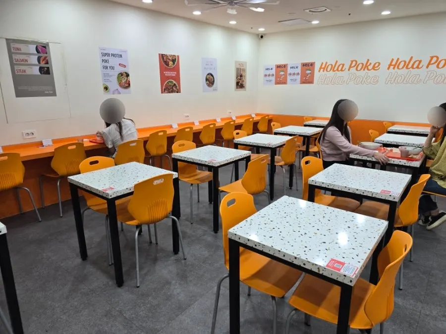 Interior of Ola Poke Gangnam lined with two-person tables