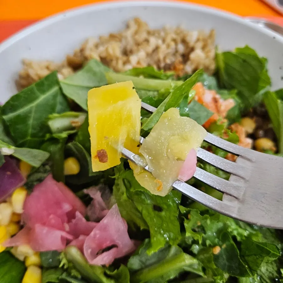 Poke salad mixed with chickpeas and pineapple