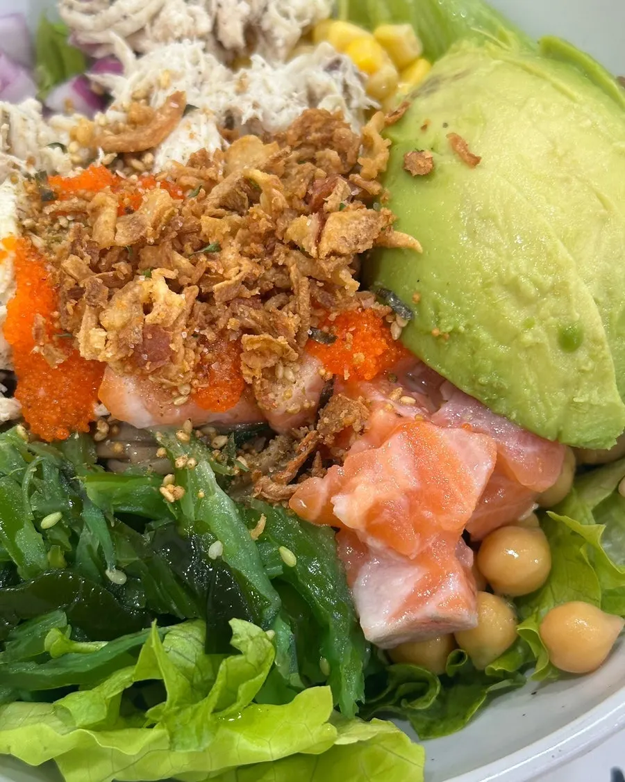 A bite of poke mixed with soba noodles and toppings