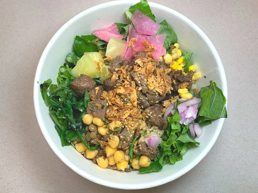 Colorful vegetables and toppings on the steak poke