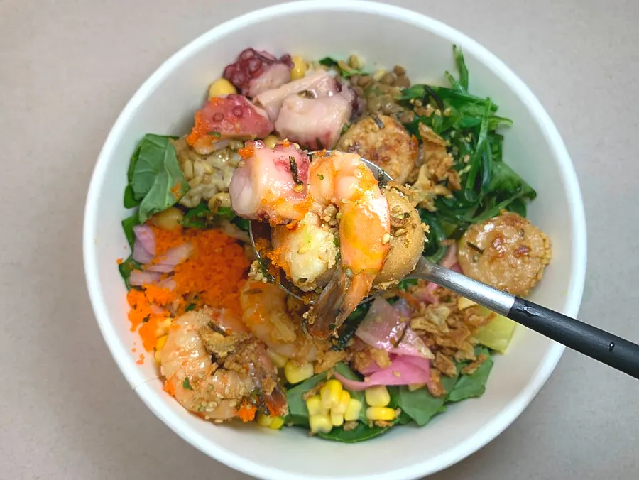 A bowl of seafood poke with a 7:3 salad-to-rice base