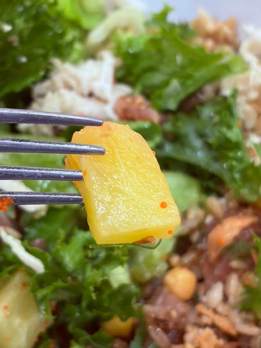 A spoonful of poke mixed with flying fish roe and vegetables