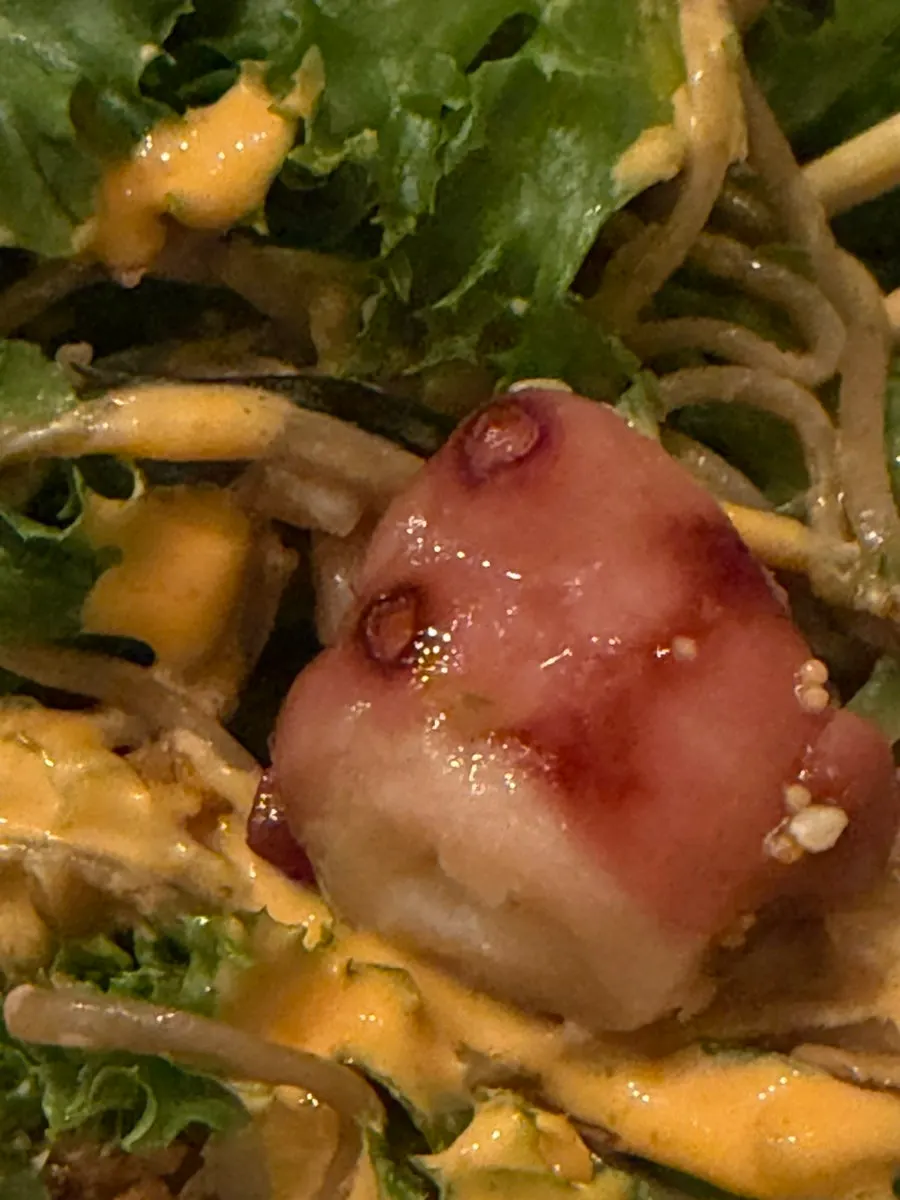 A large piece of octopus on top of the poke