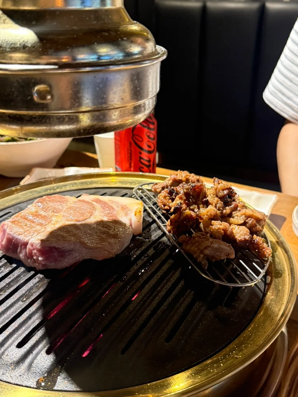 Staff grilling pork neck on the tabletop grill