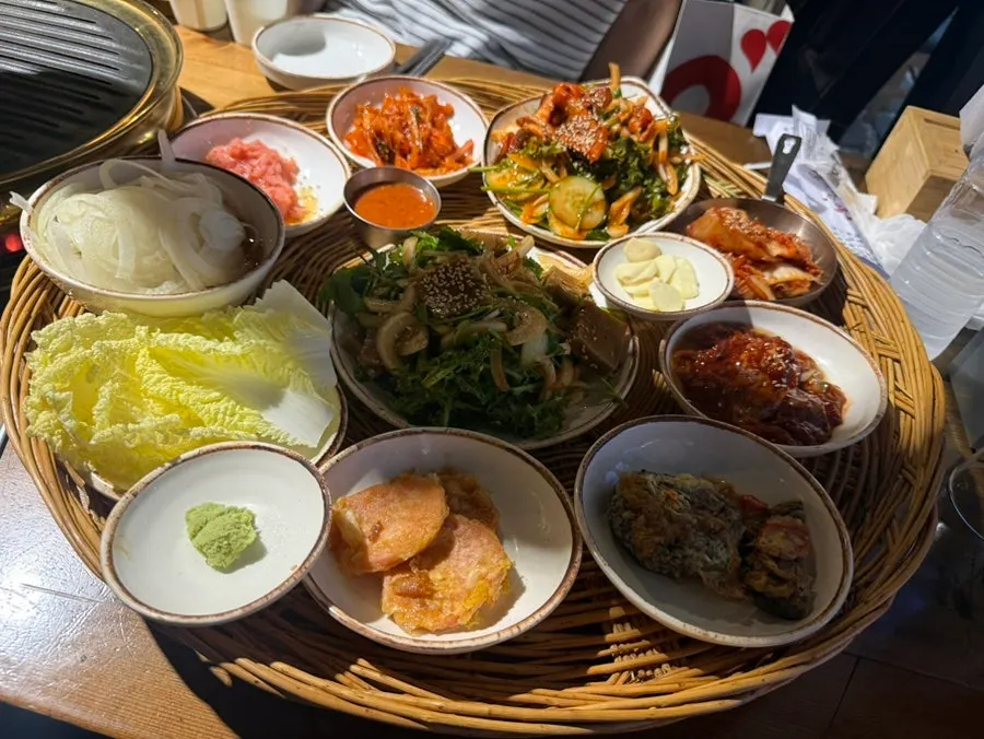 Generous spread of side dishes including acorn jelly and seasoned squid