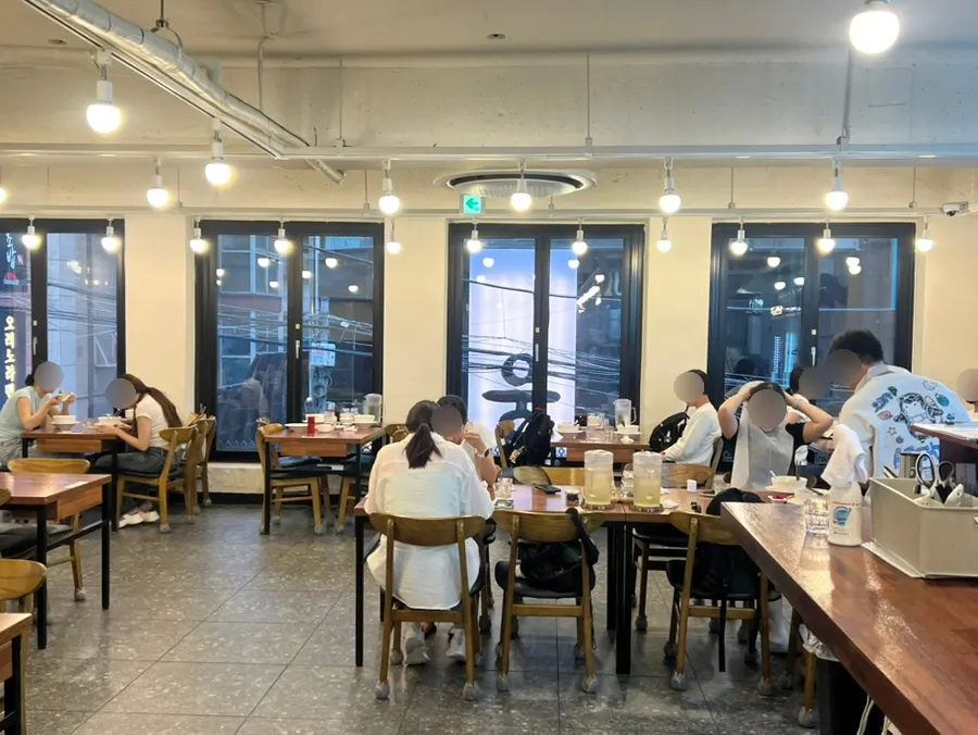 배관 노출 천장과 원목 바 테이블이 있는 매장 내부