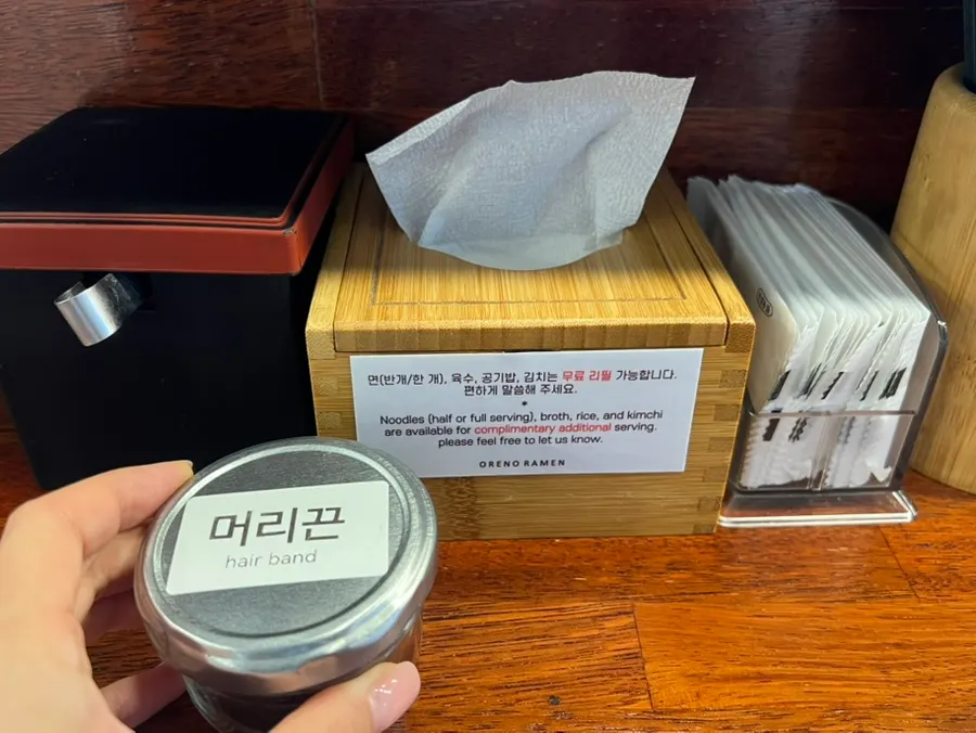 주방이 보이는 오픈형 바 좌석과 비치된 머리끈