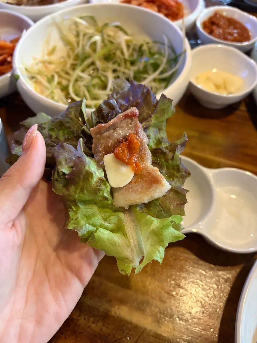 쌈채소에 올린 삼겹살과 마늘