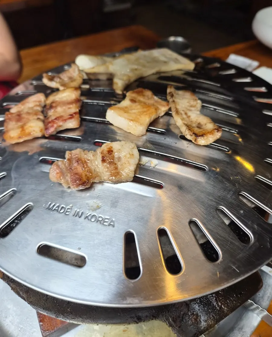 Charred grill plate with remaining pork belly