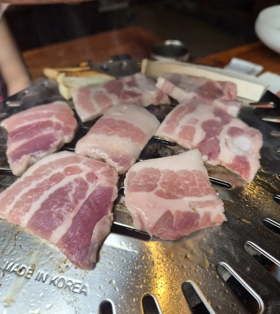 Pork belly placed on a fresh grill plate