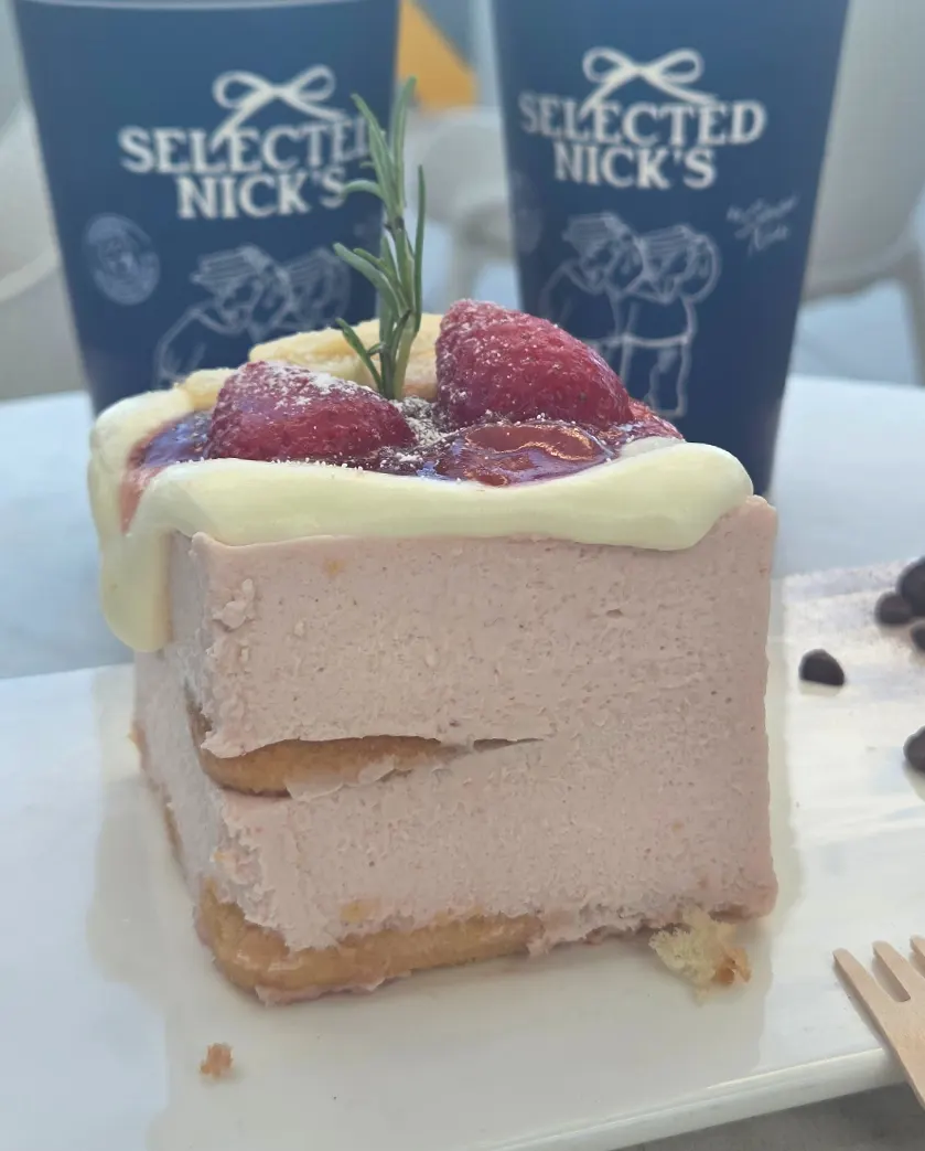 Cross-section of strawberry tiramisu with strawberries and jam on top