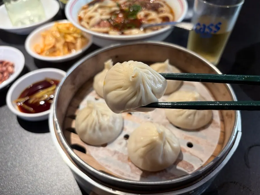 Xiaolongbao mojado en salsa de soja sobre una cuchara
