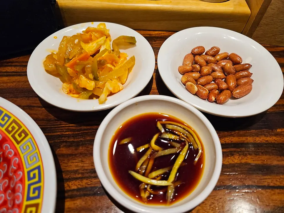 Complimentary pickled radish and roasted peanuts at Sinbok Myeongwan