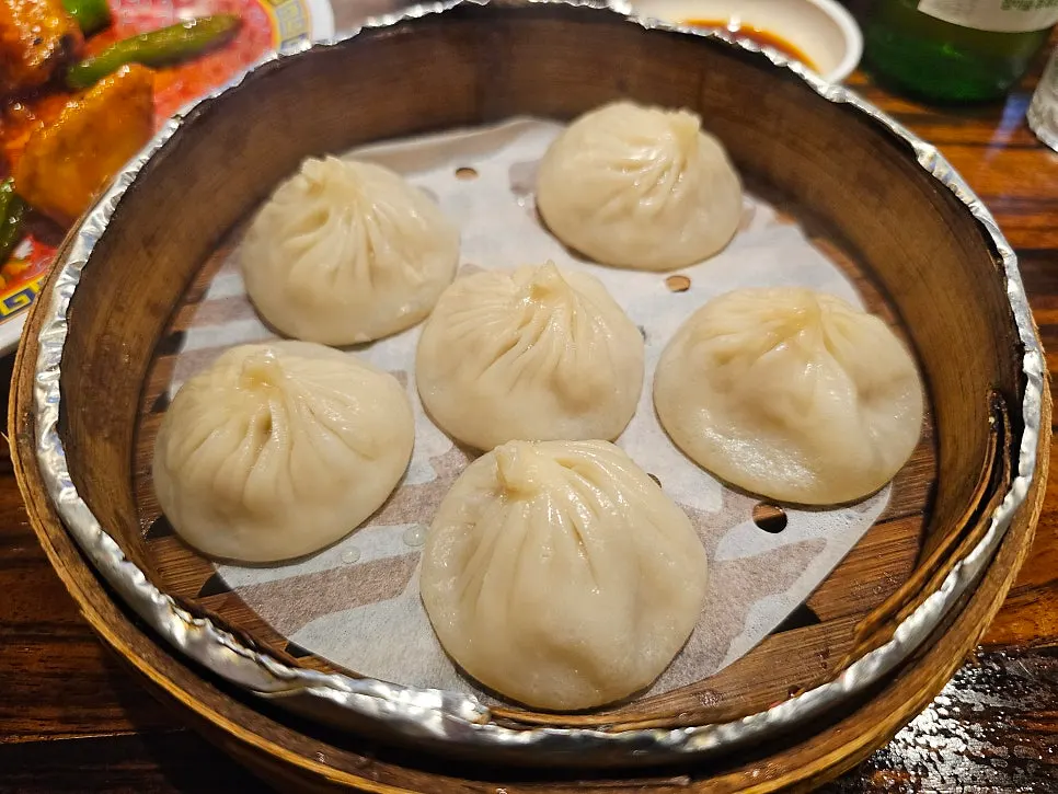 Sinbok Myeongwan's xiaolongbao dumplings served in a steamer basket