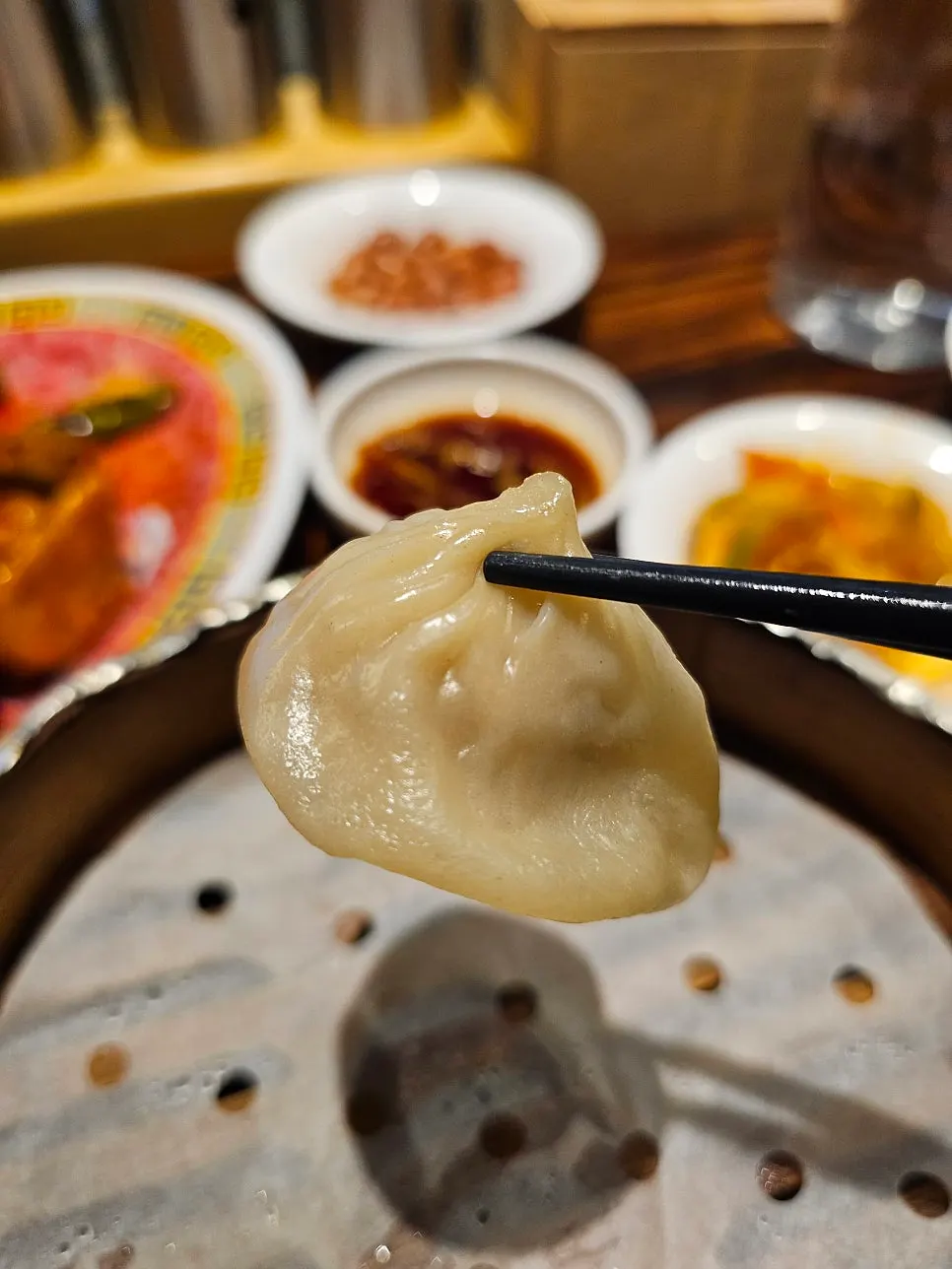 A cooled xiaolongbao dumpling picked up whole