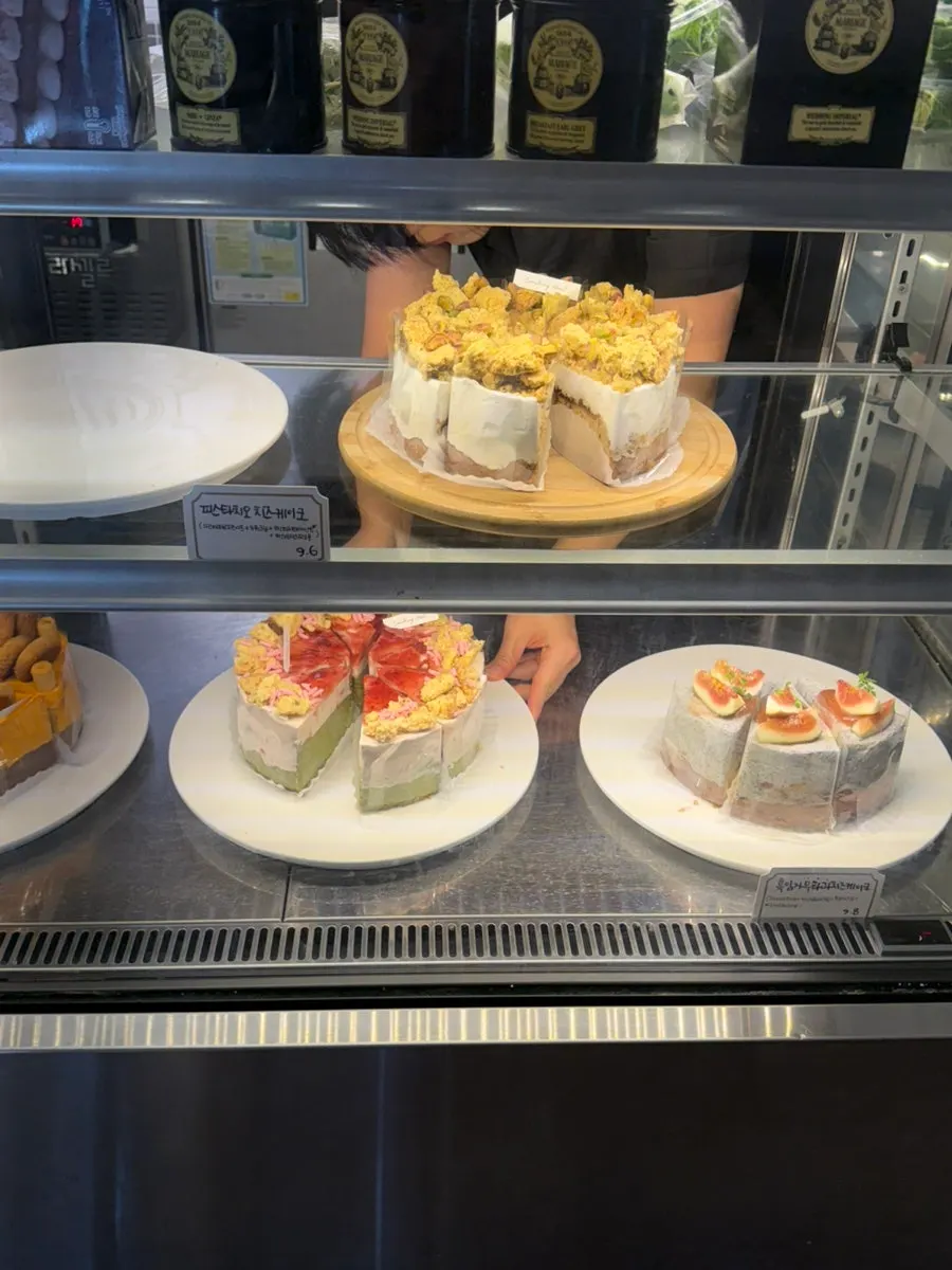 Showcase with yellow cheese, pistachio, and fig cakes