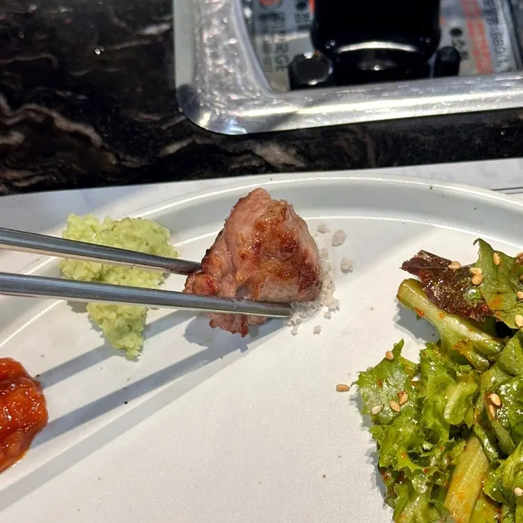 Meat being grilled at Deo Bareun Jeongyuk Sikdang Gangnam Sinnonhyeon Station Main Branch