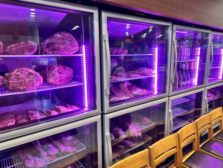 Meat-aging fridge displaying Korean beef and Jeju black pork