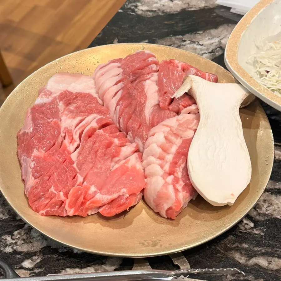 Staff grilling thick-cut pork on the grill