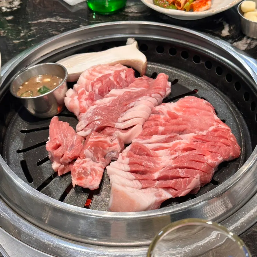 Close-up of Jeju thick-cut pork browning on the grill