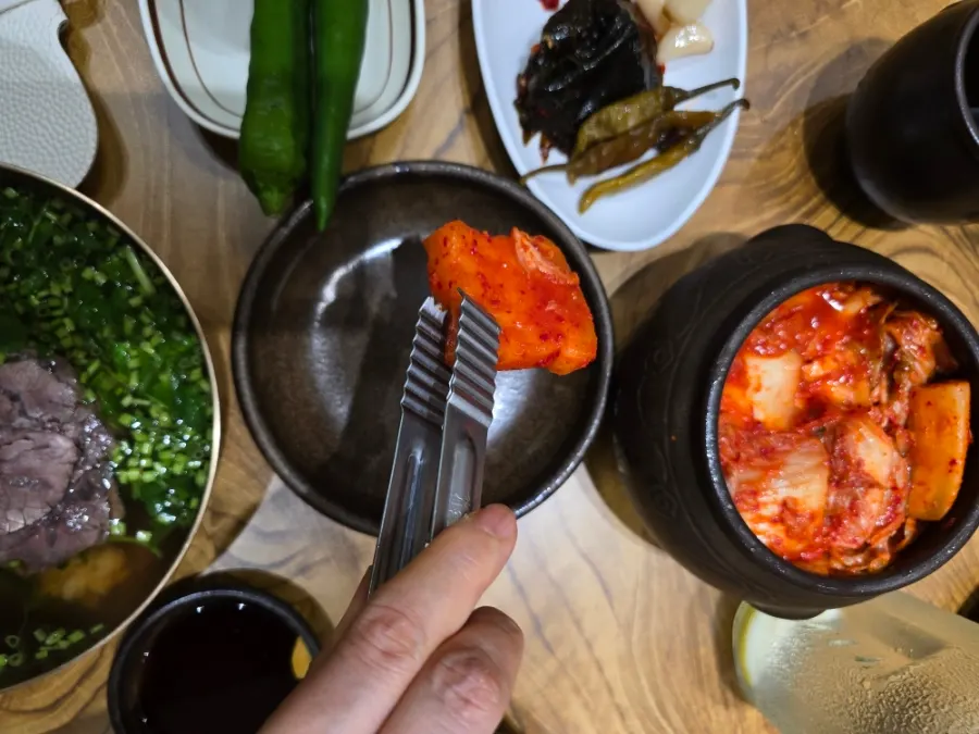 밥 위에 장아찌를 올린 곰탕 한 입